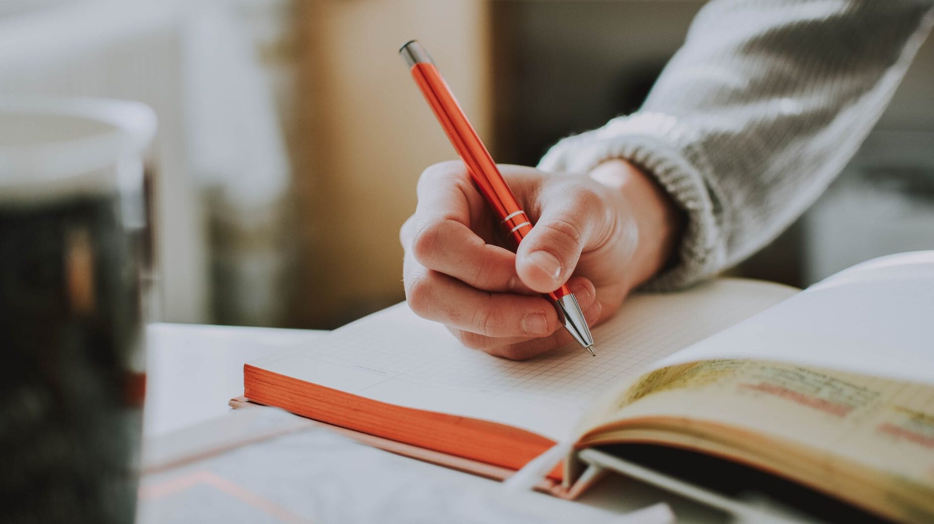 person holding orange pen